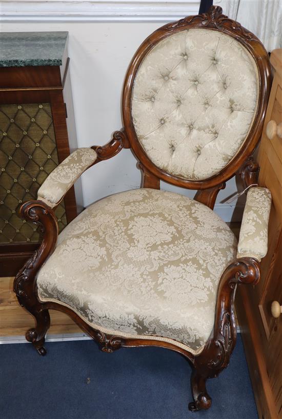 A Victorian carved round back armchair, upholstered in deep-buttoned ivory damask and a matching nursing chair